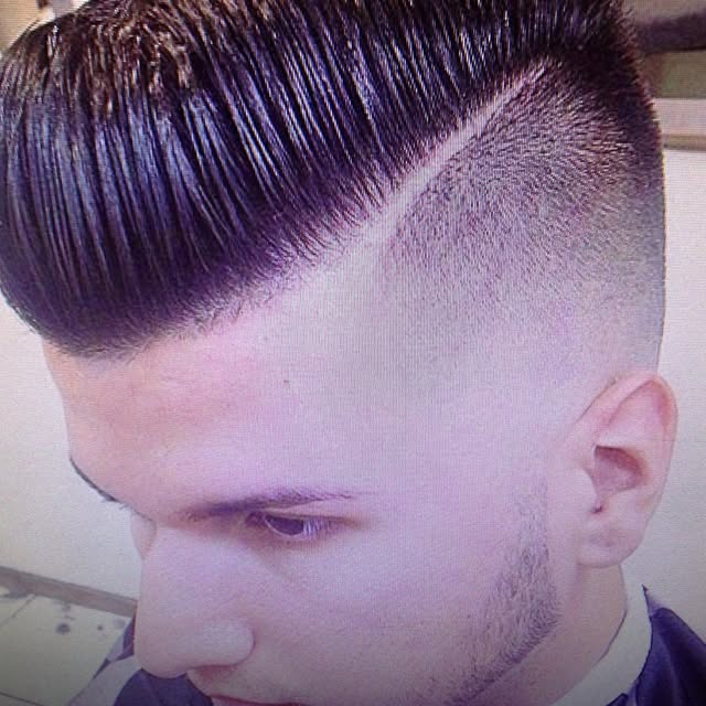 Slick pompadour with hard part and skin fade, cut at Eddie & Mark's